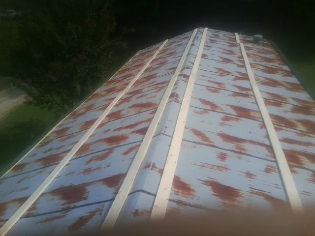 Rusted metal roof panels with new wood purlins before replacement — Storm Damage Roof Repair in Fletcher by Roofing Brothers